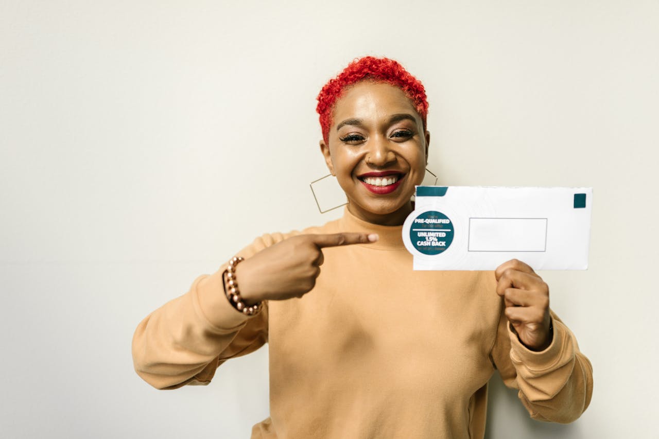 Cheerful woman pointing at an envelope with a cashback offer, emphasizing financial benefits.